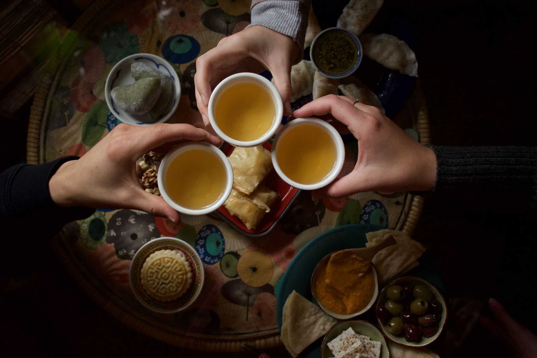 Dobra Tea - Cheers hands with tea cups and food